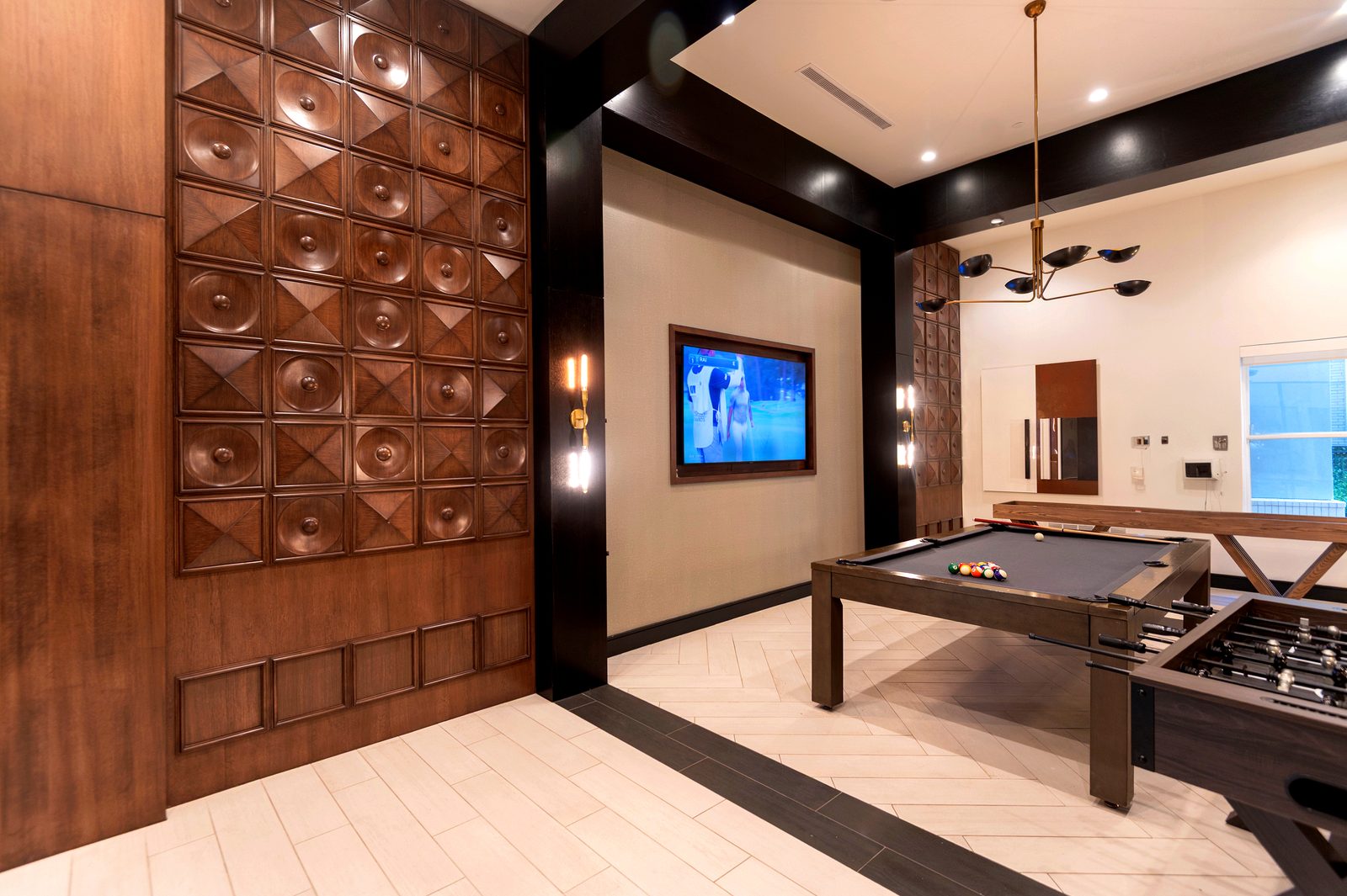 Multifamily clubhouse game room with a carved wood feature wall and pool table