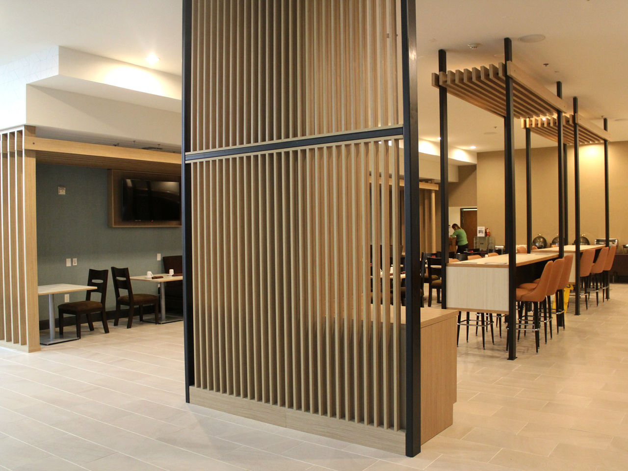 Hotel dining area with vertical wood slat screen partitions
